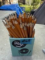 Bundle of sharpened yellow wooden pencils in teal box