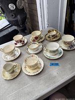 All nine teacup and saucer sets arranged on table