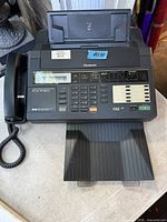 Full view of Panasonic fax machine with handset, keypad, document feeder and paper tray