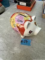 Side view of ceramic piggy bank showing collage decoration and overall appearance
