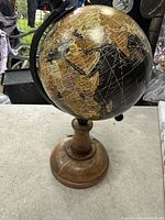 Front view of globe showing continents, wooden base, metal meridian