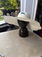Front view of off-white wide brim sun hat on stand