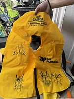 Front view of yellow Air Portugal life jacket showing logo and pictogram instructions