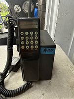 Front view showing handset keypad, antenna, and base
