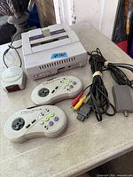 SNES console, two wireless controllers, IR receiver, AV cable, RF adapter