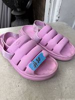 Top view of pink UGG slide sandals showing padded bands and heel straps