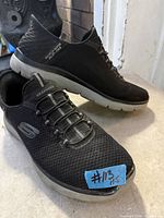 Pair of black Skechers Slip-Ins shoes showing top and side profiles with size label