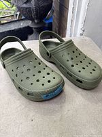 angled view of both green clogs showing uppers and heel straps
