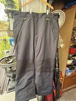 Full frontal view of winter pants hanging to show overall condition and features