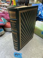 Front and spine view of leather-bound book showing gilt decoration and title