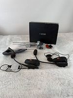 Full lot showing two intercom headsets, mics, speakers, mounts, manual and box