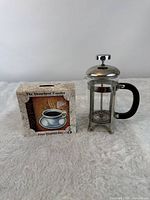 French press beside boxed AbsorbaStone coaster set