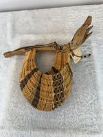 Overall view showing crescent rib basket, driftwood handle, striped weave, tag with bead