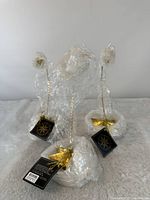 Three wrapped gold star ornament stands with tags