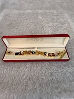 Bracelet laid flat in open red gift box showing full length and all charms