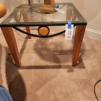Full view of one glass top end table showing materials and design