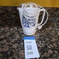 Ceramic hot water heater with power cord wrapped around body showing blue floral design and staining near base