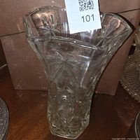 Full view of clear pressed glass vase with starburst pattern and flared rim