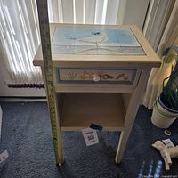 Front view showing nightstand with drawer, shelf, and measuring tape for height