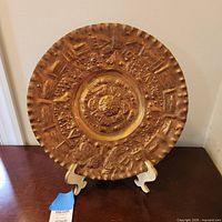 Front view of embossed copper wall plate on stand