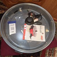 Top view showing glass lid, temperature probe, manual on skillet
