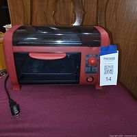 Front view of red HD506 hot dog grill with lid closed and power cord visible