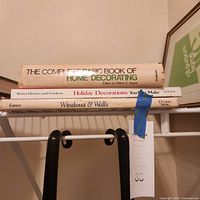 Stacked view of three hardcover books showing spines and dust jackets