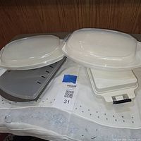 Overall view of both microwavable dishes with lids, grill insert and tray