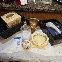 Group shot showing most items: tissue box cover in basket, wall accent, boxed massager, glass jar, porcelain ball, shell dish