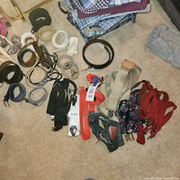 Overview of all belts and suspenders laid out on floor
