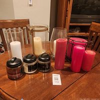Lot overview showing pillar and jar candles with various holders on table