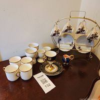 Group view of all cups and saucers on table with rack