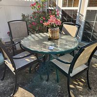 full view of table with four chairs arranged outdoors