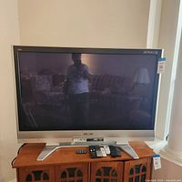 Front view of Panasonic 50-inch plasma TV with remotes on stand