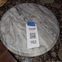 Top view of round white marble Lazy Susan showing gray veining and surface condition