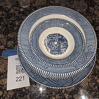 Stack of blue transferware bowl and plate showing pattern and rim