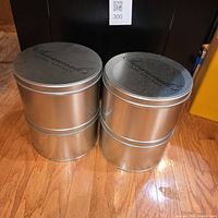 Four silver Savannah's Candy Kitchen tins stacked to show size and finish