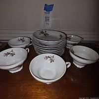 Stack of bowls with floral pattern and several cups
