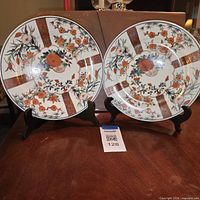 Both porcelain Imari-style plates on stands front view