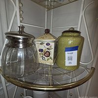 All three canisters on shelf showing materials, colors and lids