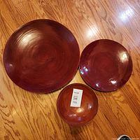 Three lacquered wood chargers grouped by size