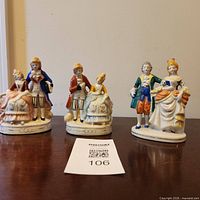 All three porcelain couple figurine groups side by side on tabletop