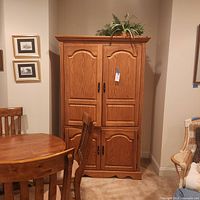 Front view of solid oak entertainment armoire with paneled doors and rope trim