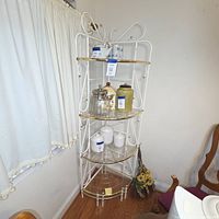 Full view of white and gold metal corner etagere with four shelves