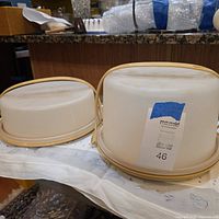 Two Tupperware cake carriers side by side on table
