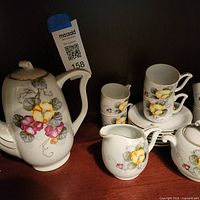 Front view of set showing teapot, creamer, cups, saucers, sugar bowl