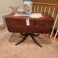 Full view of drop-leaf table showing top, pedestal, legs