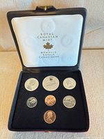 Open presentation case displaying six coins in black tray, white lid liner with Royal Canadian Mint logo