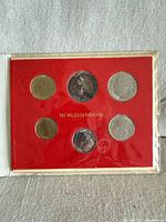 Front view of six coins in red insert marked MCMLXXXI ANNO III