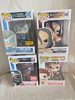 Front view of four boxed Funko Pop figures showing characters and exclusivity stickers